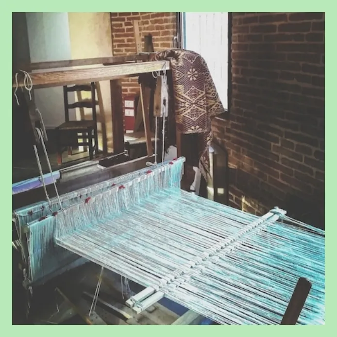 Traditional handloom setup for weaving fabric in a rustic workshop
