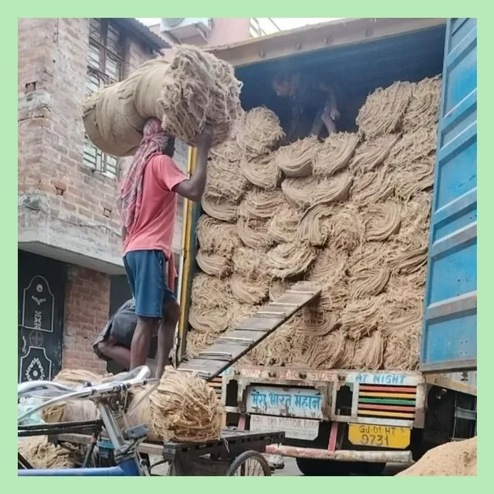 Workers loading raw jute fiber bundles into a transport truck for bulk shipment