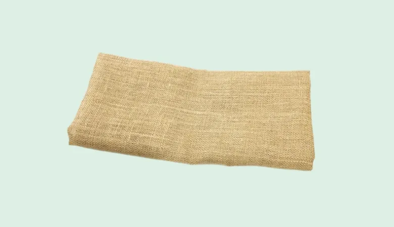 Two rolled pieces of natural brown jute fabric on a light background.